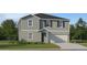 Charming two-story home with attached garage, landscaping, and neutral-colored exterior at 12025 Brae Way, Dade City, FL 33525