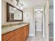 Bathroom with granite countertop vanity, framed mirror, and view into the water closet at 13618 Greenfield Dr # 105, Tampa, FL 33618