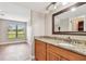 Bathroom with granite countertop vanity, framed mirror, and view into a bedroom at 13618 Greenfield Dr # 105, Tampa, FL 33618
