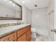 Bathroom featuring granite countertop vanity with decorative mirror and tiled shower and tub at 13618 Greenfield Dr # 105, Tampa, FL 33618