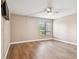 Bedroom with ceiling fan, window with view of green space, and wood laminate flooring at 13618 Greenfield Dr # 105, Tampa, FL 33618