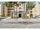 The entrance to a condo building is shown, framed by palm trees and a paved walkway at 13618 Greenfield Dr # 105, Tampa, FL 33618
