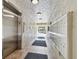 Bright hallway with tile flooring, elevator, mailboxes, and entrance to the parking area at 13618 Greenfield Dr # 105, Tampa, FL 33618