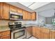 A well-lit kitchen features stainless steel appliances, granite countertops, and wood cabinets at 13618 Greenfield Dr # 105, Tampa, FL 33618