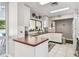 Functional kitchen with white cabinetry and a view of the sparkling pool at 13618 Greenfield Dr # 105, Tampa, FL 33618