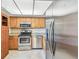 Well-lit kitchen with stainless steel appliances and light wood cabinetry at 13618 Greenfield Dr # 105, Tampa, FL 33618