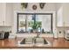 Well-lit kitchen sink area with stainless steel sink and a view of the pool at 13618 Greenfield Dr # 105, Tampa, FL 33618