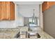 Bright kitchen with stainless steel sink, granite countertops, and view of the living room at 13618 Greenfield Dr # 105, Tampa, FL 33618
