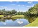 Scenic community pond with a pedestrian bridge and lush green surroundings at 13618 Greenfield Dr # 105, Tampa, FL 33618