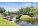 Scenic community pond with a pedestrian bridge and lush green trees at 13618 Greenfield Dr # 105, Tampa, FL 33618