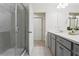 Bright bathroom featuring glass enclosed shower, neutral tile, and light gray vanity with white countertop at 14110 Damselfly Dr, Tampa, FL 33625