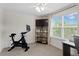Well-lit bedroom features ceiling fan, dark mounted tv and exercise equipment at 14110 Damselfly Dr, Tampa, FL 33625