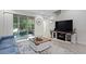 Living room with a sliding glass door for natural light, TV, and staircase at 14110 Damselfly Dr, Tampa, FL 33625