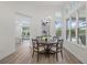 Dining room featuring wood table with view of the pool and living space with abundant natural light at 16712 Courtyard Loop, Land O Lakes, FL 34638