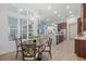 Open concept dining area with big window and view of modern kitchen, seamlessly flowing into the living area at 16712 Courtyard Loop, Land O Lakes, FL 34638