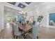 Elegant dining room features coffered ceilings, modern chandelier, and seamless flow into the adjacent living space at 16712 Courtyard Loop, Land O Lakes, FL 34638