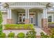Inviting front porch with stone accents, seating, and a decorative front door at 16712 Courtyard Loop, Land O Lakes, FL 34638