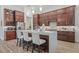 Elegant kitchen with a large center island, pendant lighting, and rich wood cabinetry, seamlessly flowing into living area at 16712 Courtyard Loop, Land O Lakes, FL 34638