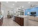 Open-concept kitchen features a large island with sink and modern appliances, seamlessly flowing into the living area at 16712 Courtyard Loop, Land O Lakes, FL 34638