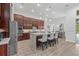 Gourmet kitchen featuring dark wood cabinetry, large island with seating, and stainless steel appliances at 16712 Courtyard Loop, Land O Lakes, FL 34638
