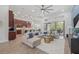 Spacious open-concept living room with modern ceiling fan, large sectional sofa, and sliding glass doors to the patio at 16712 Courtyard Loop, Land O Lakes, FL 34638