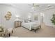Bright primary bedroom featuring tray ceilings, a ceiling fan, and neutral decor at 16712 Courtyard Loop, Land O Lakes, FL 34638