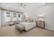 Bright bedroom with tray ceiling, decorative curtains, bench, and furniture at 16712 Courtyard Loop, Land O Lakes, FL 34638
