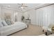 Bright primary bedroom featuring tray ceilings, a ceiling fan, and neutral decor at 16712 Courtyard Loop, Land O Lakes, FL 34638