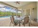 Screened lanai with a patio table and chairs overlooking a sparkling pool at 16712 Courtyard Loop, Land O Lakes, FL 34638