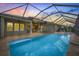 An exterior view of the screened-in pool, featuring a covered patio and outdoor seating area at 16712 Courtyard Loop, Land O Lakes, FL 34638