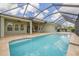 An elevated view of the pool with lush backyard and a screen enclosure for ultimate enjoyment at 16712 Courtyard Loop, Land O Lakes, FL 34638