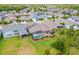 Aerial view showcases a screened pool and backyard with green grass surrounded by lush landscaping at 16712 Courtyard Loop, Land O Lakes, FL 34638