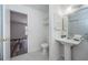 Hallway bathroom with tiled floors, large mirror, and updated fixtures at 1799 N Highland Ave # 106, Clearwater, FL 33755
