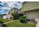 Inviting condo building with lush landscaping and unique architectural details, tile roof, and building signage at 1799 N Highland Ave # 106, Clearwater, FL 33755