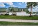 Condo building with a white fence, lush green lawn, palm tree, green roofing and siding, creating a serene atmosphere at 1799 N Highland Ave # 106, Clearwater, FL 33755