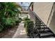 Exterior view of the condo featuring stairs to the units, greenery, and bike parking at 1799 N Highland Ave # 106, Clearwater, FL 33755