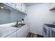The crisp white kitchen includes a stainless steel sink and new cabinet hardware at 1799 N Highland Ave # 106, Clearwater, FL 33755