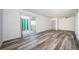 Spacious living area featuring sleek wood floors, a ceiling fan, and sliding doors leading to a balcony for outdoor living at 1799 N Highland Ave # 106, Clearwater, FL 33755