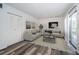 Bright living room with modern decor, stylish sofas, contemporary art, and a sliding glass door to the balcony at 1799 N Highland Ave # 106, Clearwater, FL 33755