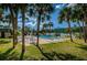 Community pool area surrounded by palm trees, lounge chairs, and tables with umbrellas at 1799 N Highland Ave # 106, Clearwater, FL 33755