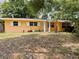 Charming single-story home with a yellow facade, white shutters, and a well-kept front lawn at 1806 Marvy Ave, Tampa, FL 33612