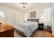 Bright bedroom with a patterned coverlet, modern ceiling fan, wood floors, and a minimalist aesthetic at 18113 Ashton Park Way, Tampa, FL 33647