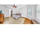 Bright bedroom with wood floors, floral rug, ceiling fan, and a large window with shutters at 2621 Stearns Rd, Valrico, FL 33596