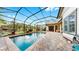 Clear swimming pool with an elegant screen enclosure and stone patio, perfect for year-round enjoyment and leisure at 2621 Stearns Rd, Valrico, FL 33596