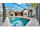 Backyard view featuring a sparkling pool, screened enclosure, and stone patio perfect for relaxation and entertainment at 2621 Stearns Rd, Valrico, FL 33596