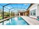 Inviting swimming pool surrounded by a screened-in enclosure and stone patio, perfect for enjoying outdoor activities at 2621 Stearns Rd, Valrico, FL 33596