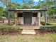 Charming backyard shed with a covered porch and rocking chairs, creating a peaceful and inviting outdoor retreat at 2621 Stearns Rd, Valrico, FL 33596