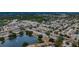 Aerial view of a community with lush trees, a tranquil pond, and well-maintained streets and homes at 3835 Sailmaker Ln # X, Holiday, FL 34691