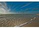 Scenic beach view capturing the sparkling ocean waves, sandy shore, and clear blue sky at 3835 Sailmaker Ln # X, Holiday, FL 34691