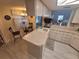 Bright kitchen boasts light countertops, white cabinetry, and stainless steel sink, with dining area in the background at 3835 Sailmaker Ln # X, Holiday, FL 34691